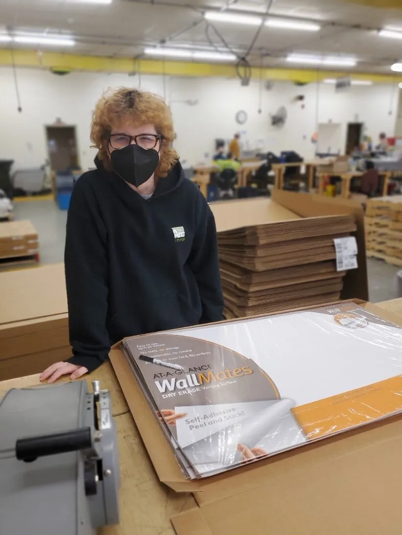 A Creekside Industries team member assembling components with hearing protection on