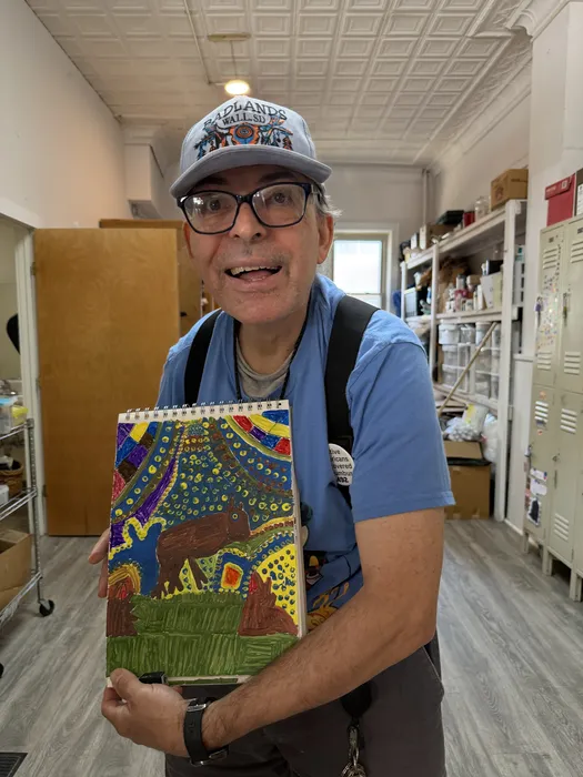 Artist proudly holding a finished piece at Main View Gallery & Studio