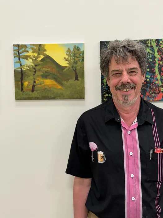 Artist beside their painting on display at Main View Gallery & Studio